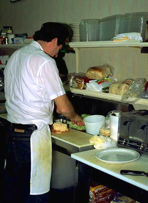 Cocinero en un bar cortando lechuga